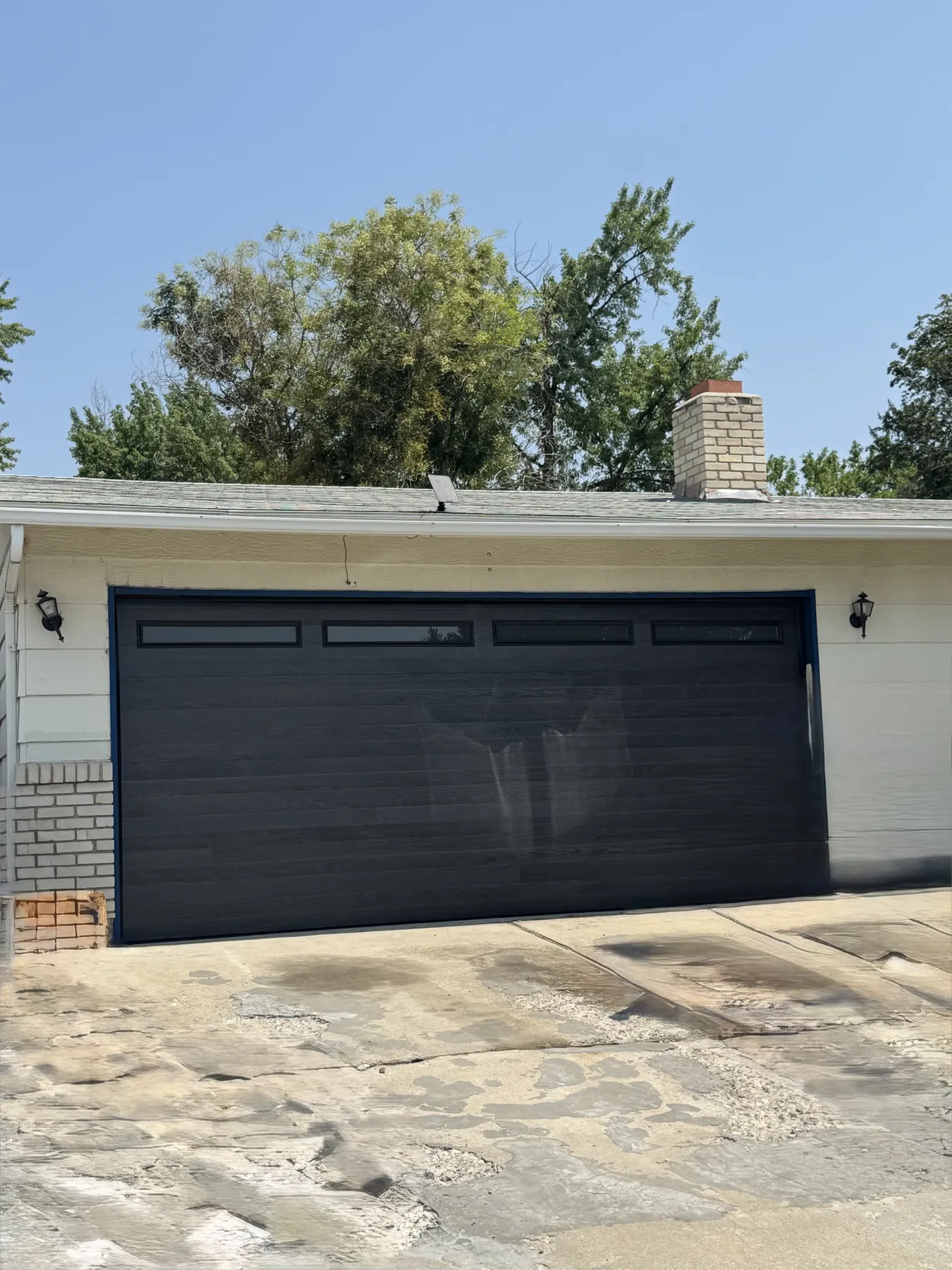 Completed black Amarr Northwoods garage door with slimline windows
